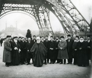 ‘Abdu’l-Bahá y su Comitiva debajo de la Torre de Eiffel en París, en 1912.